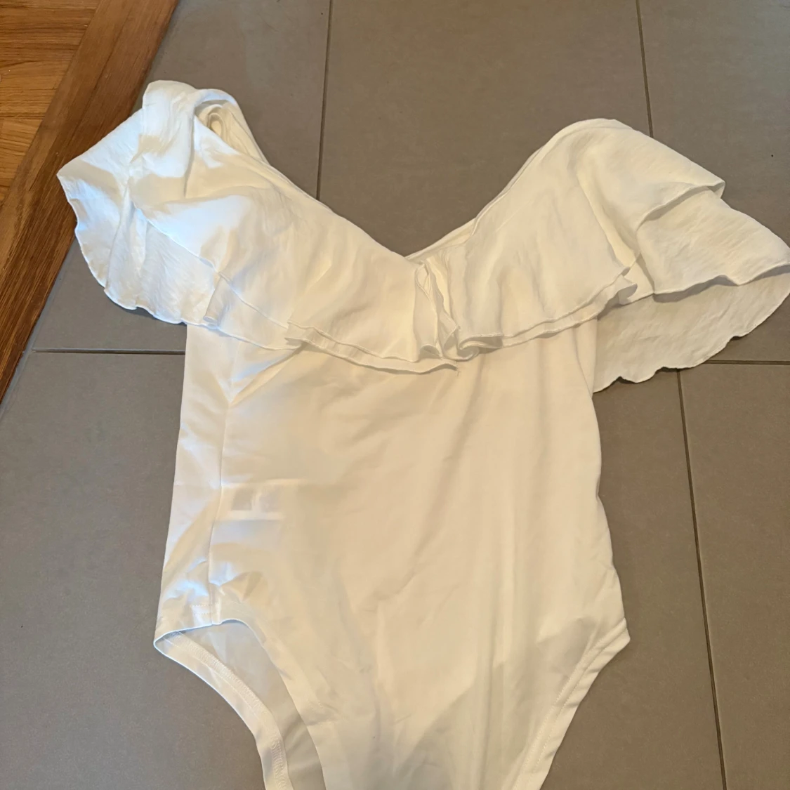 Vit off-shoulder body med volang