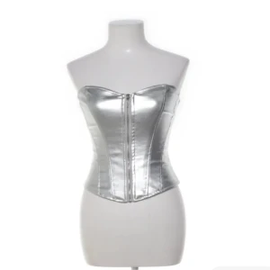 Silver korsett från Amisu, storlek S - Säljer en metallic silverfärgad korsett från Amisu i storlek S. Toppen är axelbandslös och har en snygg dragkedja framtill. Den har en figurnära passform och är tillverkad i ett glansigt syntetmaterial som ger en futuristisk vibe.