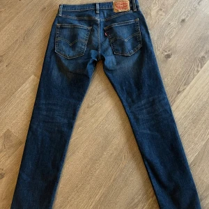 Levis Jeans Mörkblå - Mörkblåa Levi’s jeans med modell 512. Köptes i New York 2022 och har använts 3-5 gånger sedan dess. Jeansen är i väldigt bra skick utan hål, fläckar eller liknande. Storleken är W30/L32