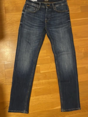 Jack & Jones comfort/mike straight jeans storlek 29/30 - Snygga blå jeans från Jack & Jones  i klassisk straight fit med kontrastsömmar och fem fickor. Jeansen har en mörk tvätt med lätt slitning och raka ben. Passar dig som gillar en enkel och tidlös stil. Storlek 29/30.