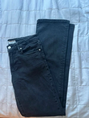 Svarta mid waist jeans från Zara - Säljer ett par svarta jeans från Zara med klassisk femficksdesign och silverfärgade knappar. Modellen har bootcut-ben och normal passform. I storlek M men passar även S. 