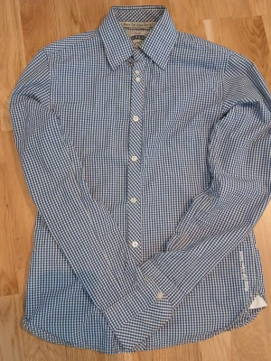 Blårutig skjorta från Scotch & Soda - Blårutig skjorta från Scotch & Soda Broderad text 'Enjoy Life Wear Scotch' vid nederkanten. Riktigt bra kvalitet. Perfekt för dig som gillar stilrena detaljer och mönster. Kan sänka priset 