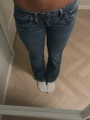 Blå valerie jeans från LTB - Säljer ett par blå jeans från LTB med bootcut-snitt och låg midja. Jeansen är tillverkade i jeansmaterial. Perfekt passform och cool tvättad look. Storlek 25/30 använt ganska mycket men syns knappt. Om ni ser på sista bilden så är det två pyttesmå hål vid fickorna. Annars är det inget fel med de. Dessa jeans passar till allt.