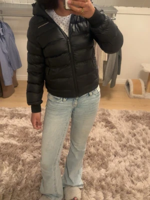 Svart dunjacka från Peak Performance - Säljer en svart dunjacka från Peak Performance med huva och dragkedja framtill. Jackan är i perfekt skick. Nypris 2500-3200kr. Funkar för både tjej och kille. Skriv för fler bilder eller detaljer!