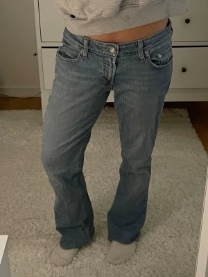 Levis ljusblå bootcut jeans - Säljer ett par klassiska Levis  jeans i ljusblå tvätt. De har låg midja och bootcut-ben. Jeansen är i mjukt denimtyg med detaljerade sömmar på bakfickorna. Perfekta för en avslappnad och trendig look. Midjemått: 38cm , innerbenslängd: 70cm 💗