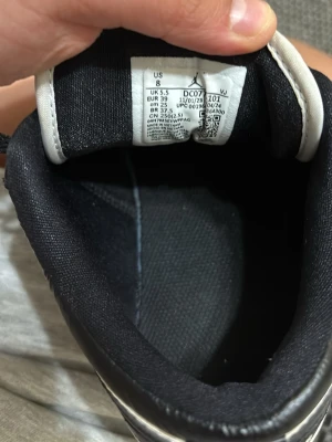 Nike Air Jordan 1 Low svart/vit US8 - Säljer ett par Nike Air Jordan 1 Low i svart och vitt. Klassisk siluett med svart skinn och vita paneler, perforerad tå och svart swoosh. Låga sneakers med snörning och ikonisk Air Jordan-logga på hälen. Perfekta för dig som vill ha en clean och tidlös look.