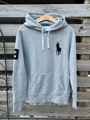 Grå Ralph Lauren Big Pony Hoodie  - Riktigt snygg och eftertraktad hoodie från Ralph Lauren. Storlek M, men kan nog även passa en större S. Fint skick, hör gärna av er vid funderingar🙌 Perfekt för vinterkylan☃️