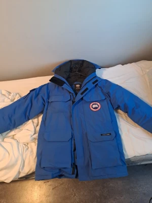 Canada Goose Expedition parka PBI Royal Blue  - Canada Goose Vinterjacka. Passar för storlek M, L och kanske XL. En av världens varmaste jackor. Jackan finns inte att köpa i butik eller online längre då färgen gjordes i mindre antal ex. Samt att Canada Goose slutade med Äkta päls 2022. Senast den fanns till salu online så låg priset på 32000kr. Pälsen finns också. Vid intresse ring 0700617350
