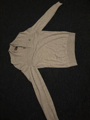 zip morris - Snygg beige långärmad tröja från Morris i 100% merinoull. Tröjan har en half zip med läderdetalj och en liten broderad logga på bröstet. Perfekt för dig som gillar stilrena och bekväma plagg med lite extra kvalitet. Säljer eftersom den är för liten.