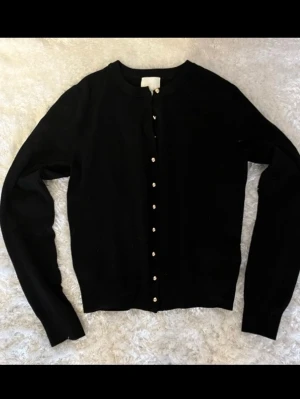 Svart Kofta med knappar - En svart tunn tygkofta med små knappar!