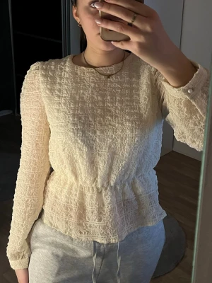 Beige blus - Säljer en beige blus med lite volang.