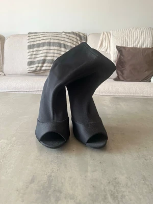 Svarta stövletter med öppen tå - Säljer ett par svarta stövletter med hög smal klack och öppen tå. Köpta på Zara i Italien. Använda en gång på nyår 