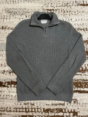 Grå stickad tröja med half zip från Core - Säljer en grå ribbstickad tröja från Core i recycled material. Tröjan har en hög krage med half zip-dragkedja och långa ärmar. Perfekt för kyliga dagar och enkel att matcha med jeans eller cargobyxor.