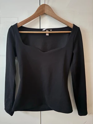 Svart långärmad topp från H&M - En svart långärmad topp från H&M. Snygg uringning och passar perfekt till fest eller vardag❤️
