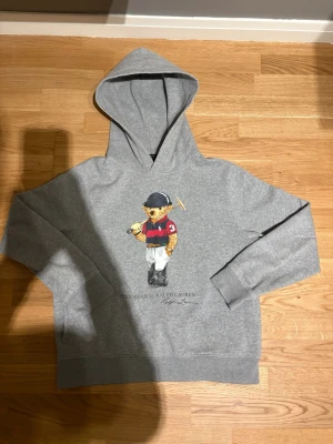 Grå polo bear hoodie  - Jag säljer en polobear hoodie i bra skick. 8/10. Passar någon som är ca 156-168