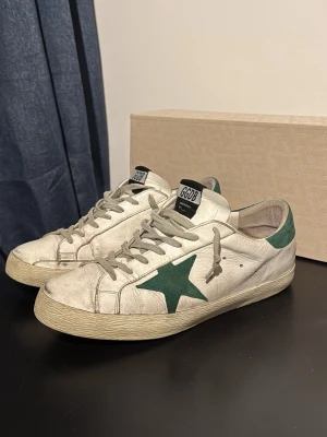 Golden Goose - Säljer nu mina populära skor från Golden Goose som är perfekta året runt. Bra skick, skorna kommer med vissa slitningar från fabrik. Storlek 43 och passar mig som har runt 42-44. Boxen ingår också! Självklart äkta. Skriv vid eventuella frågor. Priset är inte hugget i sten!