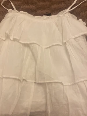 Vitt volang linne  från Gina Tricot - Vackert volang linne från Gina. Det är helt nytt och fick det i present. Så pris lappen är kvar men priset är dölja. Gina Young 170 men är själv S och passar 