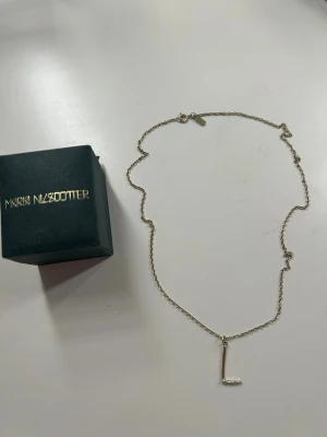 Maria Nilsdotter halsband L - Maria Nilsdotter halsband i bokstaven L. Det är i guld men har blivit mer silver, så det skiftar i guld/silver beroende på ljus osv men fortfarande mer guld än silver. Har försökt visa på bilderna. Nypris för guld ligger på 2995! Pris går absolut att diskutera!