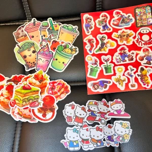 47 st Blandade klistermärken – Super Mario, Hello Kitty, mat & dryck - Färgglada klistermärken med motiv av Super Mario, Hello Kitty, söta drycker och desserter. Perfekt för att dekorera laptops, mobiler eller anteckningsböcker. Klistermärkena är i fint skick och har tydliga, glada motiv.