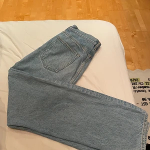 Ljusblå loose fit jeans från Arket - Säljer ett par ljusblå loose fit jeans från Arket med klassisk femficksdesign och raka ben. Jeansen är tillverkade i en mix av lyocell och ekologisk bomull, vilket gör dem både mjuka och hållbara. Perfekta för en avslappnad och trendig look. 30/32