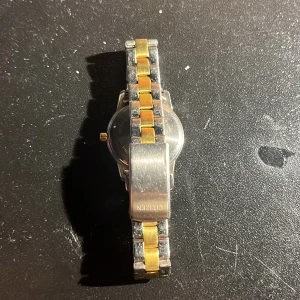 Citizen armbandsur i silver och guld - Citizen armbandsur med klassisk rund urtavla, datumvisning och kvartsverk. Länken är i tvåfärgad design med både silver- och guldfärgade partier. Klockan har metallarmband och stilren look som passar till många outfits.  Prisetkan diskuteras och serienummer som visas på bild är #8N1220253