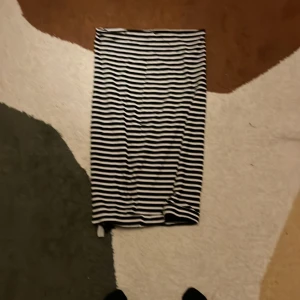 Randig svartvit kjol från H&M - Säljer en svartvit randig kjol från H&M Basic i storlek S. Kjolen är rak i modellen och har horisontella ränder. Tillverkad i mjuk bomull med lite stretch för extra komfort. Perfekt för dig som gillar enkel och stilren design.