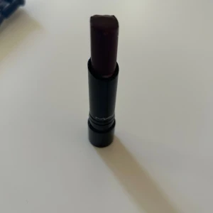 MAC Sheen Supreme läppstift mörklila - MAC Sheen Supreme Lipstick i nyansen Good To Be Bad. Läppstiftet har en djup mörklila färg med glansig finish. Snygg svart hylsa med MAC-logga. Perfekt för dig som vill ha en statement-läpp med mycket pigment.