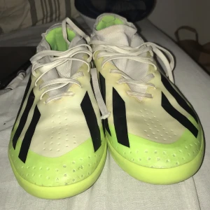 Adidas Crazyfast fotbollsskor lime - Adidas Crazyfast fotbollsskor i limegrönt och vitt med svarta detaljer. Skorna har snörning, platt sula och rund tå. Tillverkade i syntetmaterial med ventilerande mesh på ovansidan. Perfekta för dig som vill sticka ut på planen med snabb känsla och snygg design.