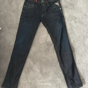 Mörkblå Replay jeans straight fit - Snygga mörkblå jeans från Replay med klassisk femficksdesign och raka ben. Jeansen har kontrastsömmar, Replay-logga på fickan och läderpatch bak i midjan. Perfekta för dig som gillar clean look.