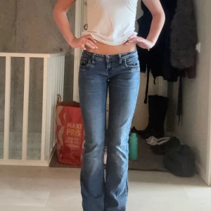 Blå bootcut jeans från LTB - Snygga blå jeans från LTB med bootcut passform och låg midja. Jeansen har klassisk femficksdesign, dragkedja och knapp framtill. Materialet är stretchigt denim som sitter skönt och följer kroppen. Perfekta för dig som gillar en tidlös look med lite utsvängda ben. Dom har hål mellan benen men är inget som syns när man går runt i dem och går enkelt att laga🥰 W26 och L32