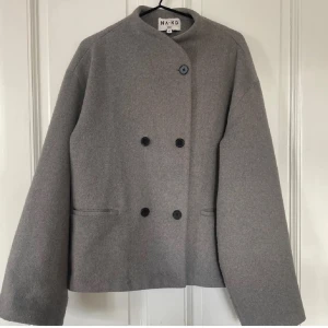 Kort ulljacka ifrån NAKD - Superfin jacka ifrån NAKD i ullmix! Köptes förra året för 1095kr har använts men i bra skick förutom, sömmen på ena ärm-slutet ( på insidan) har släppt något men går lätt att laga  med några stygn!🌟🌟kan skicka bild på det i chatten