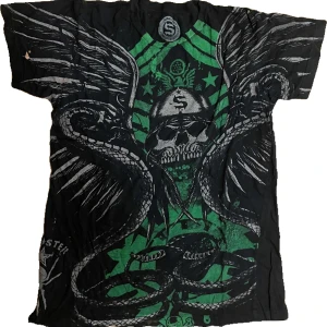 Svart T-shirt med coolt tryck - Den är i man storlek S-M. Osäker på mer information eftersom lappen är borttagen. Har en liten fläck på höger ärm.