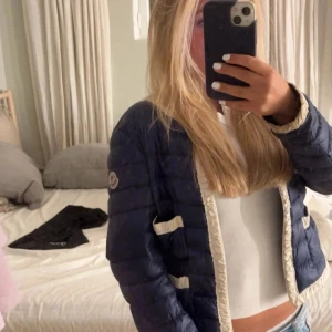 Blå dunjacka från Moncler - Säljer en snygg blå dunjacka från Moncler med quiltad design. Jackan har en dragkedja framtill och långa ärmar. Perfekt för kyligare dagar. Passar bra till både jeans och kjol. 🧥💙