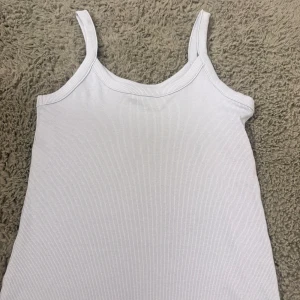 Ljusblå ribbad linnetopp från H&M - Säljer en ljuslila ribbad linnetopp från H&M i storlek 158/164. Toppen har smala axelband och ärmlös design.