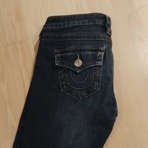 True Religion Joey Low Rise Flare köp/byta -  HÖR GÄRNA AV ER VID INTRESSE!! Svarar oftast väldigt snabbt ❤️❤️❤️Snygga mörkblå jeans från True Religion, modell Joey Low Rise Flare. De har låg midja, utsvängda ben och ikoniska bakfickor med lock och dekorativa sömmar. I storlek w25!💕 I modellen Joey, Har en pyte lite defekt men det syns inte (kan skicka bild bara fråga) Går och att byta mot samma märke!! 🤗