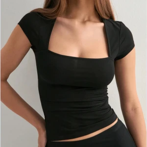 Snygg svart topp!! - En snygg svart tröja från Nelly, har bara testat den 1 gång och har kvar lappen, den är jätte snygg men passar tyvärr inte mig!! skriv för fler frågor! 🩷🫰🏼