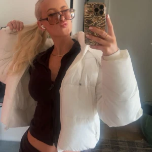 ALO puffer jacket Ivory - Säljer en snygg vit pufferjacka från ALO köpt i LA med huva och dragkedja. Jackan är quiltad och har en modern, lite kortare passform. 