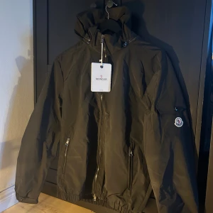 Moncler windbreaker/vindjacka - Säljer en svart vindjacka från Moncler i storlek M! Den är aldrig använd och alla lappar sitter kvar. Det går att scanna den. Hör av dig vid funderingar!