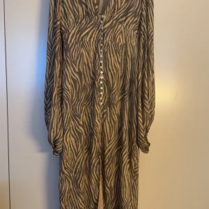 Adoore klänning - Säljer den populära adoore klänningen i storlek 42. Passar mig som vanligtvis är 38.  Använt två gånger.  Saknas två knappar längst ner som försvann i tvätten. Men enkelt att sy på nya. Se bild 2. Annars i nyskick. 