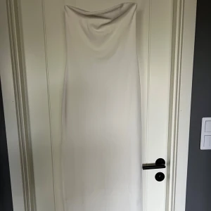 Vit klänning  - Vit klänning utan band med slits baktill. 