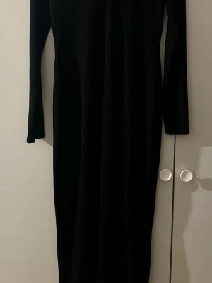 Svart långärmad ribbad klänning Bubbleroom - Säljer en svart långklänning från Bubbleroom i storlek M. Klänningen har ribbad struktur och långa ärmar, med en stilren och enkel design som är lätt att matcha. Perfekt för dig som gillar minimalistiska och tidlösa plagg.