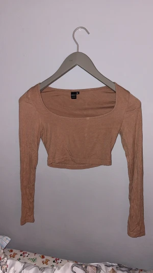 Beige croppad långärmad topp - Beige/Brun långärmad tank top från Shein. Det är liten liten fläck som går bort vid tvätt. Syns bara vid extrem ljus.   XS men passar S också.  aldrig använd 