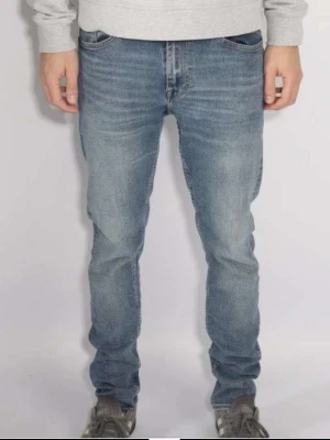 Tiger Of Sweden ljusblå skinny jeans - Säljer ett par Toger of Sweden jeans i ljusblå tvätt med klassisk femficksdesign och smal passform. Jeansen har låg midja och är tillverkade i mjukt bomullsmaterial med lite stretch för extra komfort. Perfekta för dig som gillar en modern och slim look.