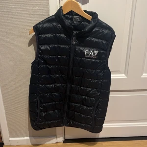 Emporio Armani EA7 Dunväst - Tja! Säljer en svart dunväst från Emporio Armani EA7. Västen är i storlek XL men den sitter som en L. Hör av dig om mer bilder eller funderande om priset! Mvh Vidar 