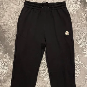 Moncler mjukisbyxor  - Svarta Moncler mjukisbyxor med broderad logga på benet med raka ben. Tillverkade i mjukt bomullsmaterial som är skönt mot huden. Perfekta för chill eller träning med klass med en clean och stilren look, pris kan diskuteras vid snabb affär.