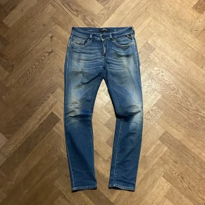 Replay Hyperflex jeans blå - Säljer ett par Replay Hyperflex jeans i modellen New Luz. De är blå med snygga slitningar och har klassisk femficksdesign, dragkedja och broderade detaljer på bakfickorna. Jeansen är tillverkade i stretchigt jeansmaterial för extra komfort.
