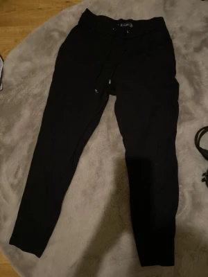 Svarta mjukisbyxor - Säljer ett par svarta mjukisbyxor med fickor på sidorna och där bak. Tillverkade i mjukt material. Finns inga defekter.