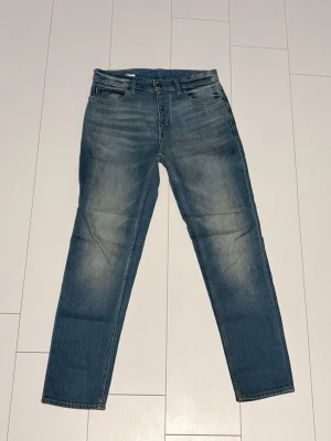 Hugo boss Jeans  - Snygga blå jeans med raka ben och klassisk femficksdesign. Jeansen har en ljus tvätt med subtila slitningar framtill och bak, samt normal midja. Perfekta till en avslappnad stil och tillverkade i mjukt bomullsjeansmaterial.