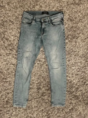 Replay ljusblå slimfit jeans - Säljer ett par ljusblå slimfit jeans från Replay med klassisk femficksdesign och Replay-lapp bak i midjan. Jeansen har smal passform, normal midja och är tillverkade i mjukt denimtyg för en bekväm känsla. Perfekta för en avslappnad och trendig look. Priset är inte hugget i sten och kan sänkas vid snab affär! 