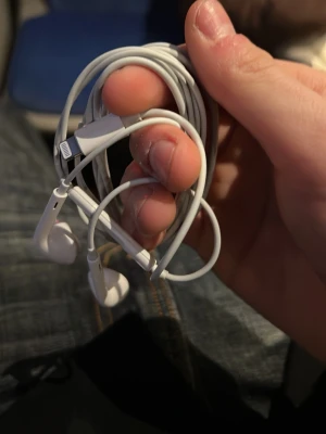 Vita Apple EarPods med sladd - Säljer ett par klassiska vita Apple EarPods med Lightning-kontakt. De har rundade öronsnäckor och en sladd i tålig plast. Perfekta för dig som vill ha smidig anslutning till iPhone och bra ljud. Har allt för många par av dessa o säljer helt rena och som nya